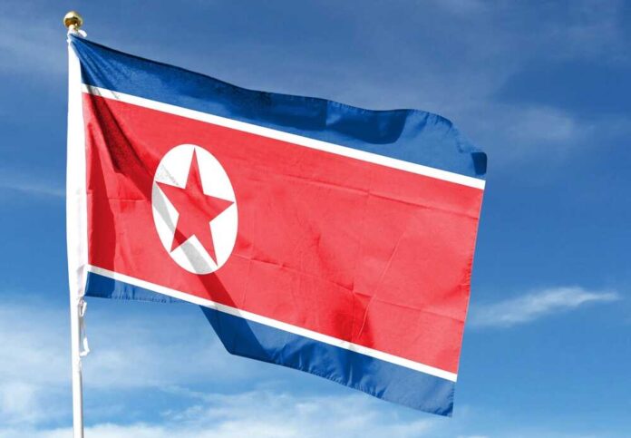 North,Korea,Flag,In,The,Cloudy,Sky.,Waving,In,The