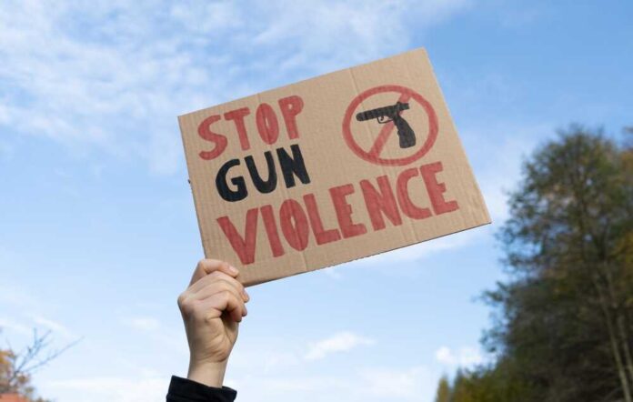 Hand,Holding,A,Sign,With,Slogan,Stop,Gun,Violence,And