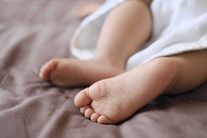 Baby,Feet,Taking,A,Nap,With,Brown,Sheets