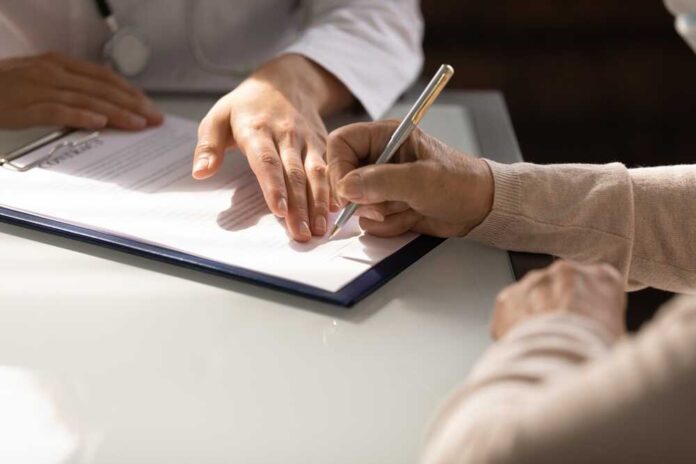 Hands,Of,Woman,Filling,Document,At,Appointment,In,Doctor,Office.