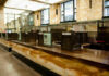 Interior of a historic bank with marble walls and empty counters