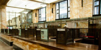 Interior of a historic bank with marble walls and empty counters