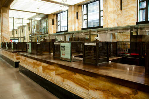 shutterstock_1095803672.jpg Interior of a historic bank with marble walls and empty counters