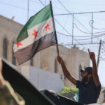 Man holding Syrian opposition flag during protest