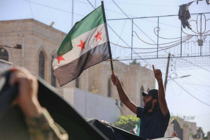 Man holding Syrian opposition flag during protest
