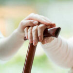 Medicare SCAM: Seniors Targeted in $46M Fraud Hands resting on a wooden cane together