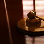Gavel on a wooden table in sunlight