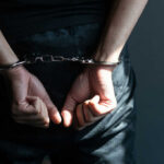 Hatchet Rampage: Family Ties Severed in Bloodbath Person with hands cuffed behind back in handcuffs