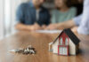 Model house and keys on a wooden table