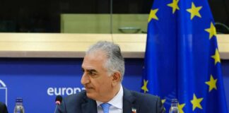 Crown Prince Reza Pahlavi attending a political meeting in front of the EU flag