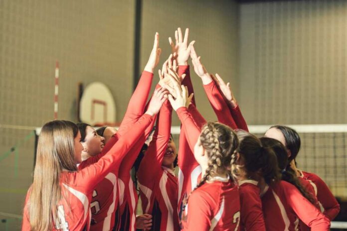 Volleyball players celebrating with hands raised together