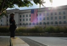 Pentagon’s Secretive Stock Gambit Sparks Outrage A Marine standing guard in front of the Pentagon with an American flag in the background