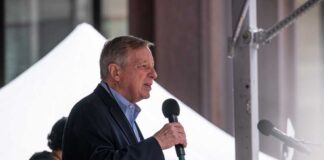 A man speaking into a microphone at an outdoor event