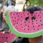 Mural Controversy: When Global Symbols Offend Locally Child wearing a watermelon mask at a festive event