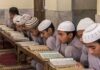 Young students studying the Quran in a classroom setting
