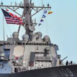 A naval destroyer displaying the American flag and various signal flags