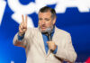 Man speaking on stage in front of blue background