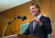 Gas Prices Soar: Newsom’s Blame Game Exposed Man speaking at podium with microphone