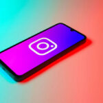Smartphone displaying Instagram logo in colorful lighting