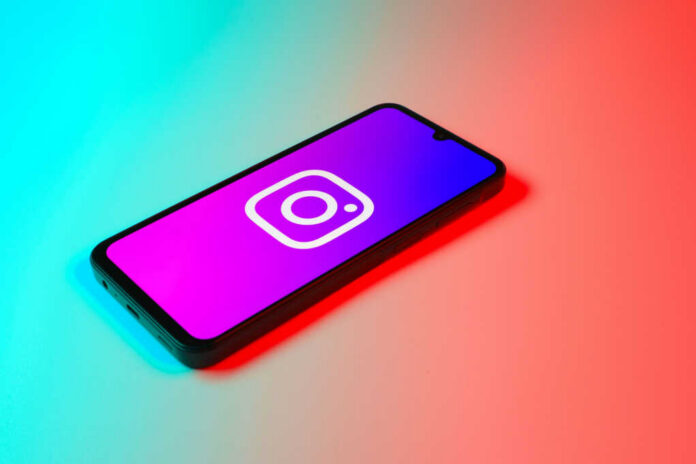 Smartphone displaying Instagram logo in colorful lighting