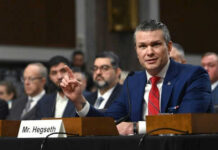 Man speaking at a panel discussion meeting
