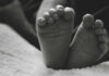 Close-up of a baby's feet resting on a soft surface