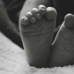 Close-up of a baby's feet resting on a soft surface