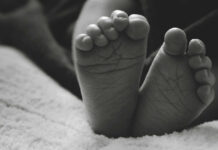 Close-up of a baby's feet resting on a soft surface