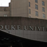Sign displaying 'Duke University' on a modern building