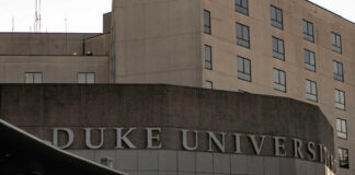 Sign displaying 'Duke University' on a modern building