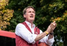 Person speaking outdoors while holding a basketball