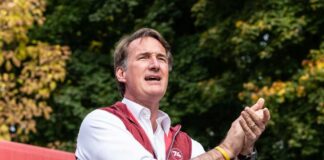 Person speaking outdoors while holding a basketball