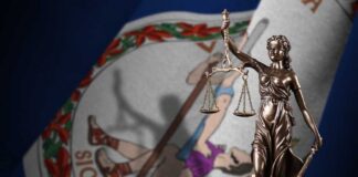 Bronze statue of Lady Justice in front of the Virginia state flag