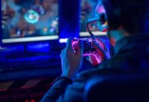 Person playing video games with a controller in a dimly lit room