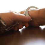 Close-up of a handcuff being secured on a wrist