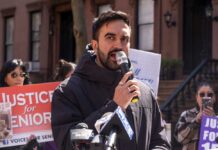 Man speaking into a microphone at a protest for senior justice