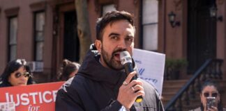 Man speaking into a microphone at a protest for senior justice