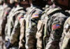 Soldiers in camouflage with American flag patches standing