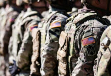 Soldiers in camouflage with American flag patches standing