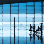 People at airport with wheelchair and reflections on floor