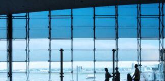 People at airport with wheelchair and reflections on floor
