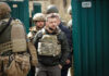 Group of soldiers, including Volodymyr Zelenskyy, wearing tactical gear.
