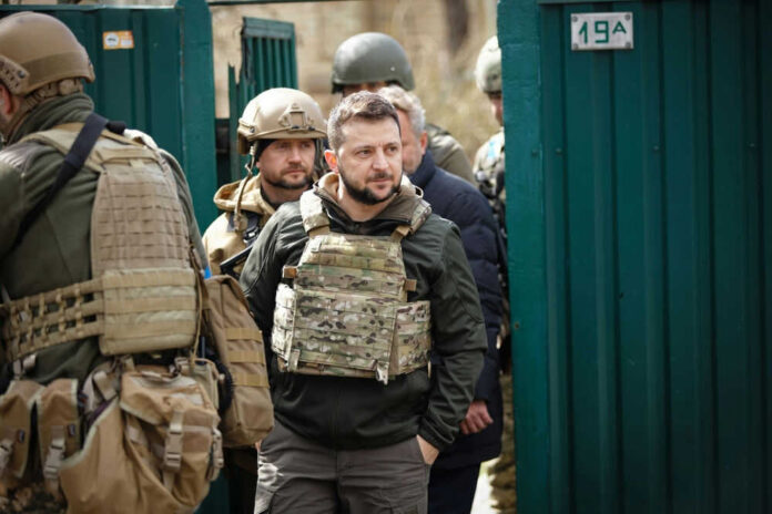 Group of soldiers, including Volodymyr Zelenskyy, wearing tactical gear.