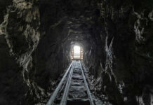 Dark tunnel leading to bright exit with tracks