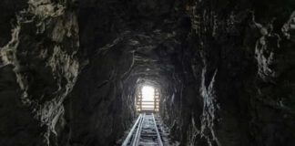 Dark tunnel leading to bright exit with tracks
