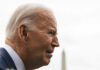 Elderly man in profile with grey hair outdoors.