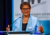 Woman speaking at a podium in blue jacket