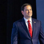 Wedding DJ Rubio: America’s “Secretary of Everything” Man in suit with red tie on stage