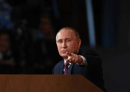 Person pointing while speaking at a podium