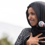Ilhan Omar Subpoena Blocked by One Vote Ilhan Omar speaking at a microphone during an event
